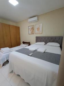 ein Schlafzimmer mit zwei Betten mit weißer Bettwäsche in der Unterkunft casa ampla com PISCINA e área verde em São José ao lado de Maragogi in São José da Coroa Grande + 38 Fotos