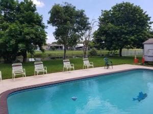 a group of chairs and a swimming pool at Flats Hospitality in Plantation