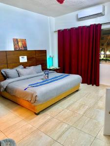 ein Schlafzimmer mit einem großen Bett mit roten Vorhängen in der Unterkunft Amir Palace Hotel in Aqaba