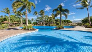 una piscina con palmeras en un resort en 4 Bdrm House for 8 at Kamilo, Mauna Lani -- Ride Bikes or Walk To Beach, en Waikoloa
