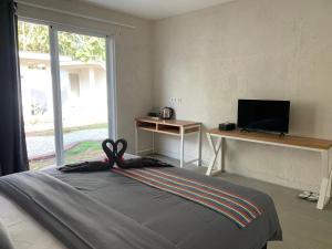 a bedroom with a bed and a desk and a window at Casa Della by Kahurangi in Sekongkang