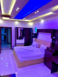 ein Schlafzimmer mit einem großen Bett mit violetter Beleuchtung in der Unterkunft Amir Palace Hotel in Aqaba