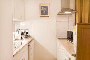 a kitchen with white cabinets and a sink at Authentic Grand Boulevard in Budapest