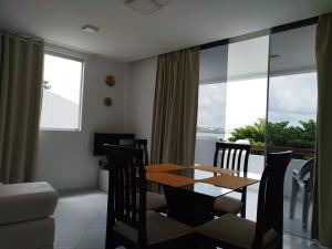a dining room with a table and chairs and a balcony at Habana Flats Praia in Natal +16 photos
