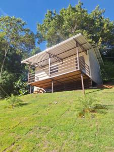 a house on top of a hill in a field at Chalé Roda Dágua B in Alto Caparao
