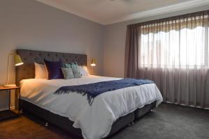 a bedroom with a large bed with a large window at Affordable Quality - Kooringal, Wagga in Lake Albert