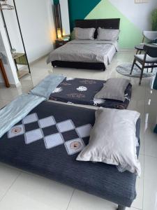 two beds and pillows on a bed frame in a room at Mahkota Valley Apartment Indera Mahkota Kuantan#Netflix in Kuantan +27 photos