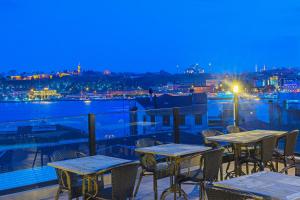 a patio with tables and chairs on a balcony at night at Ada Karakoy Hotel - Special Category in Istanbul