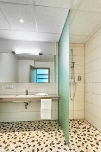 a bathroom with a sink and a mirror at Hotel 2050 in Rutesheim