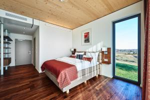 1 dormitorio con cama y ventana grande en Hotel 2050 en Rutesheim