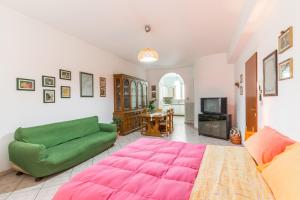 a living room with a large pink bed and a couch at Il Paesino - La Veranda in Licodia Eubea