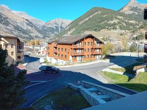 une voiture roulant sur une route avec des montagnes en arrière-plan dans l'établissement Apartment with parking near River, à Val Cenis