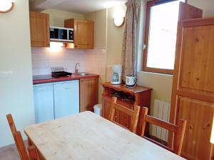 a small kitchen with a wooden table and a window at Apartment with parking in Val Cenis in Val Cenis +13 photos