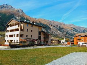 a building with a mountain in the background at Apartment with parking in Val Cenis in Val Cenis