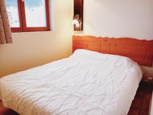 a bedroom with a white bed with a wooden headboard at Apartment in Northern Alps with balcony in Val Cenis
