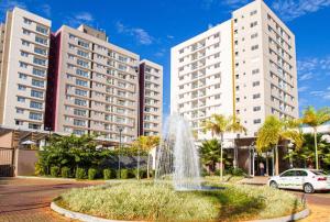 a fountain in front of two tall buildings at Evian Residence Caldas Novas in Caldas Novas