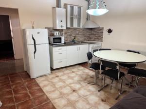 a kitchen with a table and a white refrigerator at Altos del Thompson in Paraná
