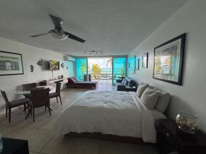 a bedroom with a bed and a desk and a table at Ocean view Studio Marina Lanais in Fajardo +16 photos