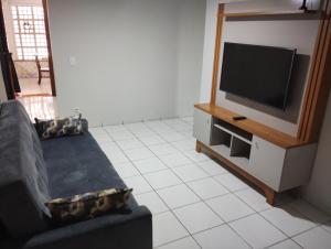 a living room with a couch and a flat screen tv at Casa em Itapoá in Vila Velha +15 photos