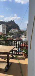 Un balcón con bancos y vista a una calle. en MINH HUY HOUSE Mộc Châu, en Mộc Châu