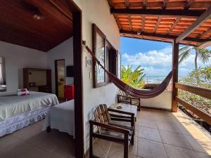 a bedroom with a hammock and a view of the ocean at Chez Max Pousada in Morro de São Paulo