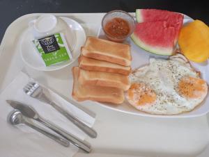 a plate of breakfast food with eggs bread and fruit at Tsada Balay Homestay in Guindulman +12 photos