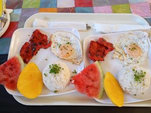 a tray with eggs and fruit on a table at Tsada Balay Homestay in Guindulman