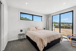 a bedroom with a bed and a large window at The Alpine Patch - Wanaka Holiday Home in Wanaka