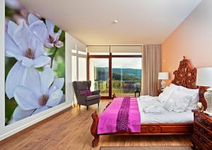 a bedroom with a large flower mural on the wall at 12 Meses Naturalmente in Cerdeira