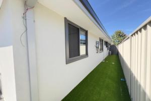 a hallway with green grass next to a building at B2 Airport Adjacent Home - New Amenities & Fast Wi-Fi in Perth