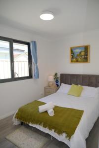 a bedroom with a large bed with a green blanket at B2 Airport Adjacent Home - New Amenities & Fast Wi-Fi in Perth