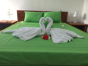 a bed with two swans made out of towels at Linggy Homestay in Nusa Lembongan
