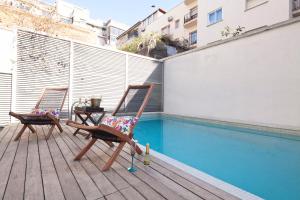 バルセロナにあるMy Space Barcelona Private Pool Gardenのスイミングプールの隣のデッキに座る椅子2脚