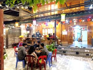 a group of people sitting at a table in a restaurant at A Kiệt Homestay in Mèo Vạc