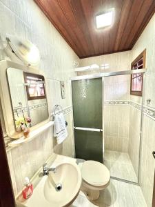 Un baño con ducha, inodoro y lavabo. en VHL Apartamentos, en Campos do Jordão