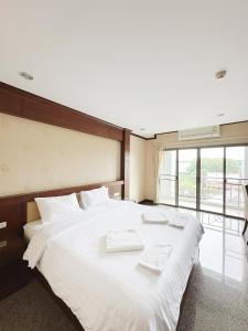 a large white bed in a room with a window at Green Hill Hotel Phayao in Phayao +18 photos
