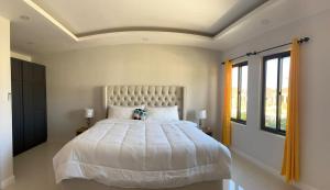 um quarto com uma grande cama branca em um quarto em Roses Cove, Serene & tranquil, a slice of peace em Ocho Rios mais 24 fotografias
