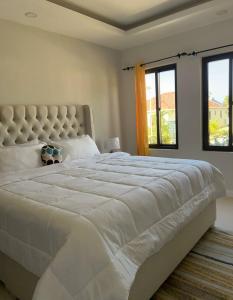 uma grande cama branca num quarto com janelas em Roses Cove, Serene & tranquil, a slice of peace em Ocho Rios