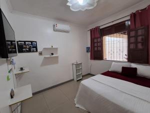 a bedroom with a white bed and a window at Linda casa para COP 30 in Belém