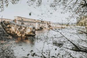 a bridge over a body of water with a bridge at Simplistic Luxury Cottage, Ross in Ross +5 photos