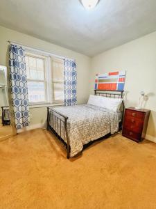 a bedroom with a bed and a dresser and a window at Rose's comfortable place in Munhall