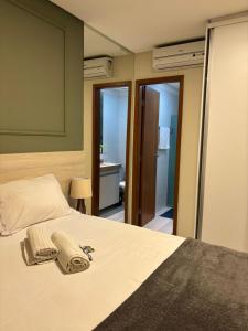 a bedroom with a bed with two towels on it at Flat Rosarinho II - Confortável e Super Completo in Recife +18 photos