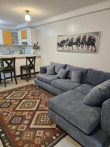 a living room with a grey couch and a kitchen at Departamento Edificio Playa Blanca in La Serena