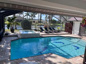 ein Pool mit Liegestühlen um ihn herum in der Unterkunft Villa Endless Love in Cape Coral