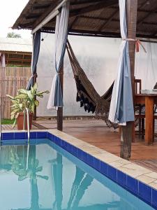 a hammock in a house with a swimming pool at La Casa Magno's Ajuruteua in Bragança