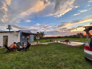 eine Gruppe von Menschen, die an einem Tisch im Hof sitzen in der Unterkunft El Retoño in Esquina