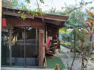 a wooden pergola with a table in a garden at บ้านอนัตตา in Ban Thung Kwang