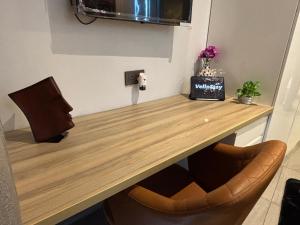 a wooden table with two chairs in a room at Luxury Vello Stay Supernova in New Delhi