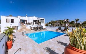 a villa with a swimming pool in front of a house at Luxury House Panoramic Sea Views in Güime