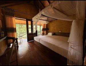 a bedroom with two bunk beds and a window at Sinharaja Riverside in Deniyaya